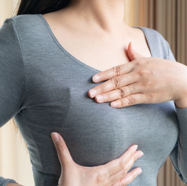 midsection of woman touching chest