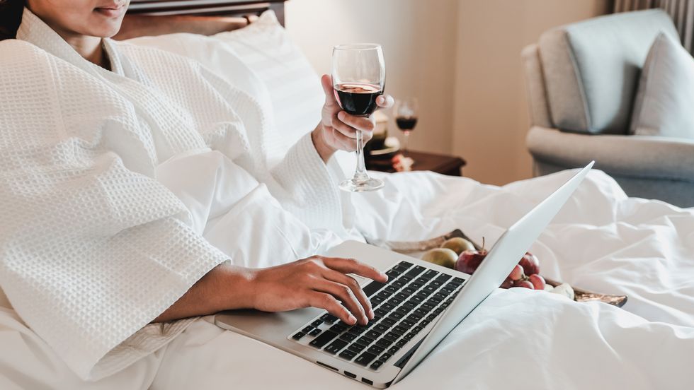 Midsection Of Woman Using Laptop On Bed