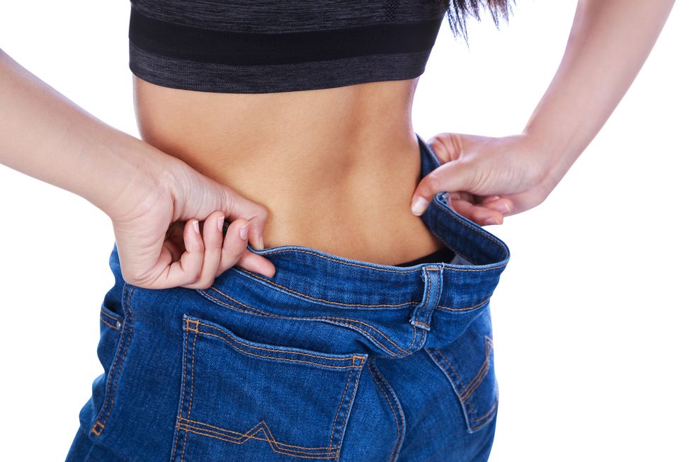 midsection of woman wearing jeans against white background