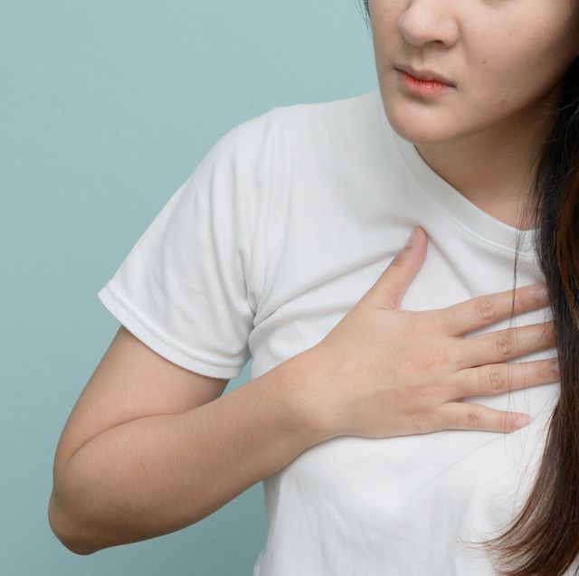 midsection of woman with chest pain against blue background