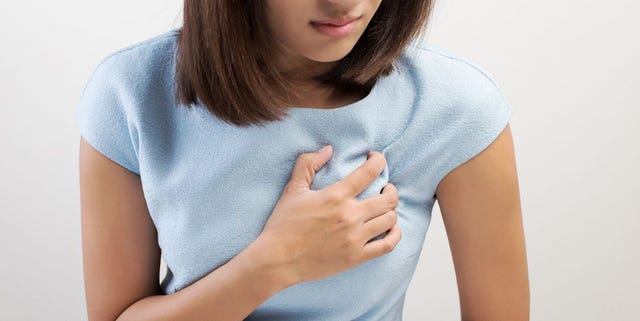 midsection of woman with chest pain against white background