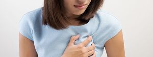 midsection of woman with chest pain against white background