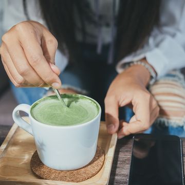 mujer removiendo una taza de té verde