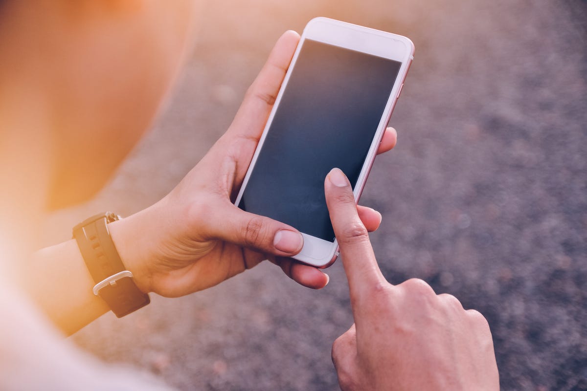 Midsection Of Young Man Using Mobile Phone