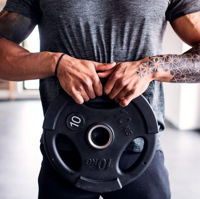 midsection of young man doing exercise in gym