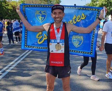 runner celebrating with a medal and flag after a race