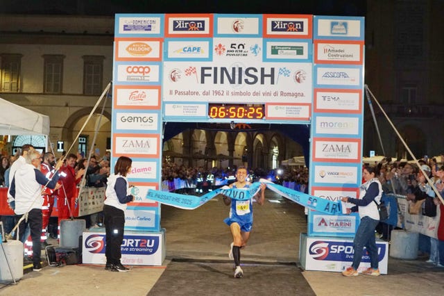 runner crossing the finish line at a marathon event