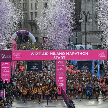 start line of the wizz air milano marathon with runners and a cheering crowd start line of the wizz air milano marathon with runners and a cheering crowd