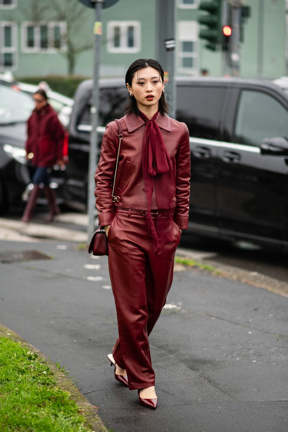 person dressed in burgundy attire walking on a street