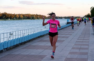 runner in a pink shirt participating in a race alongside a body of water