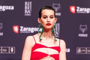 milena smit con vestido rojo con aberturas y pendientes de serpiente en los premios feroz