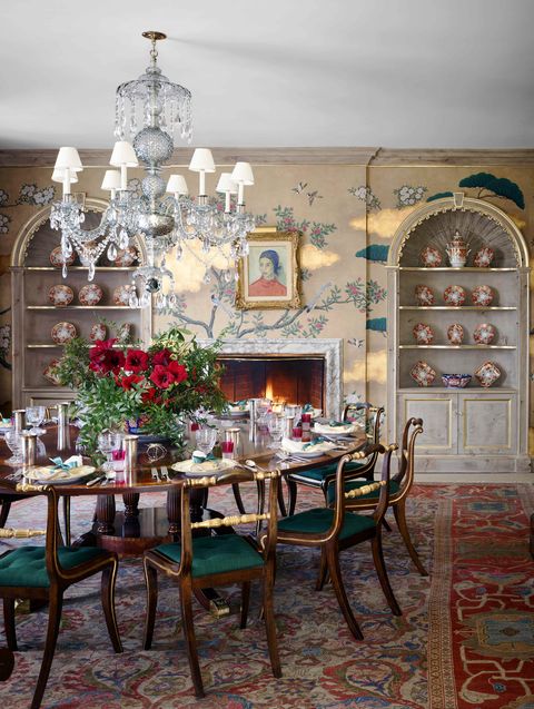 a round dining table with chairs all around and a crystal chandelier above