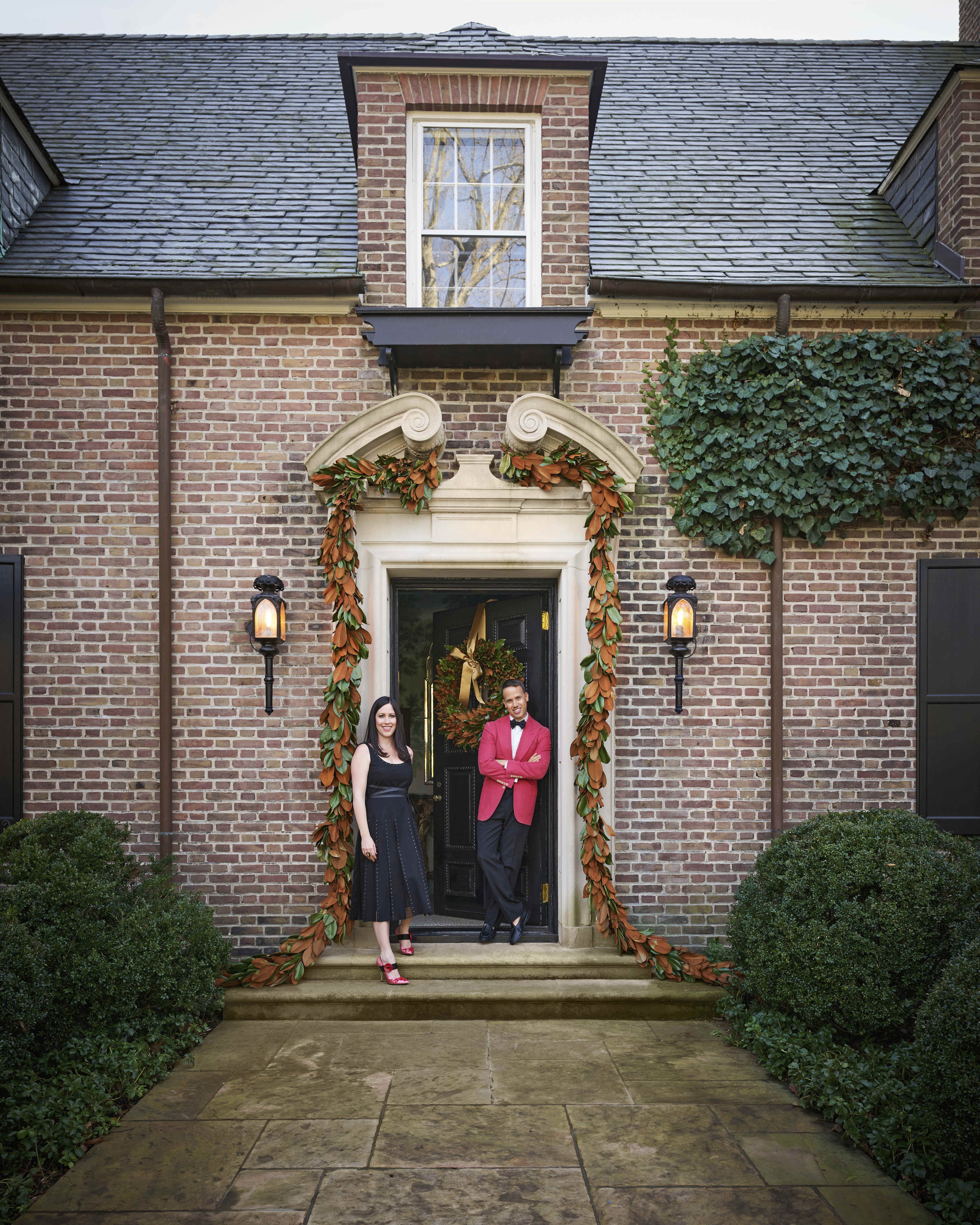 the brick exterior of a connecticut house with a man and woman standing at the front door