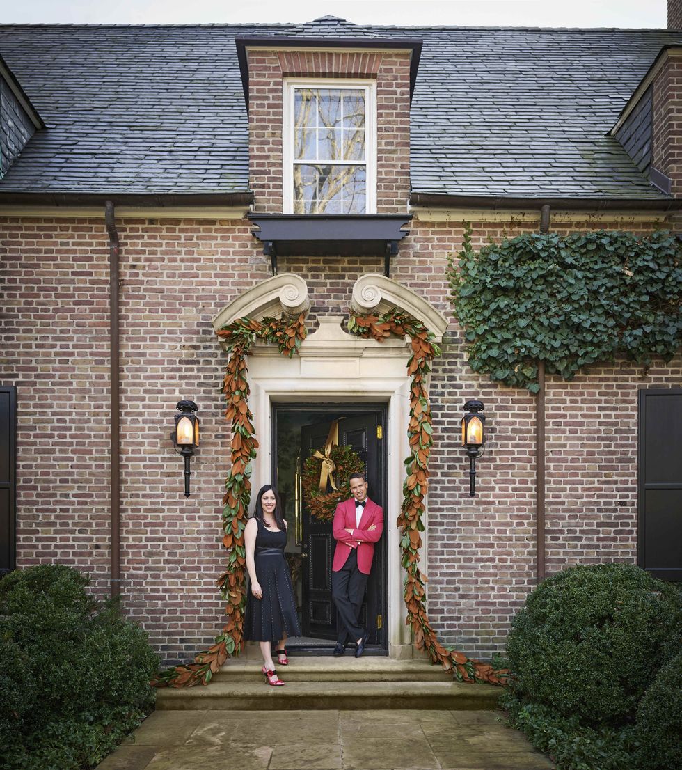 the brick exterior of a connecticut house with a man and woman standing at the front door
