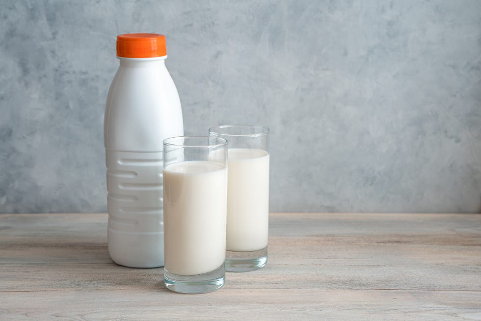 a bottle of milk and two glasses filled with milk