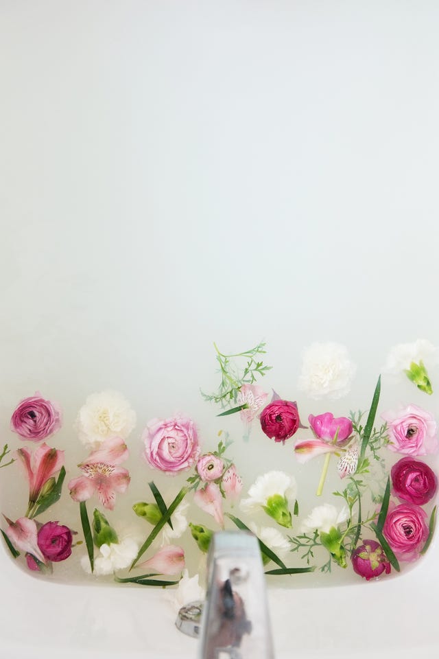flowers floating under faucet in a milk bath