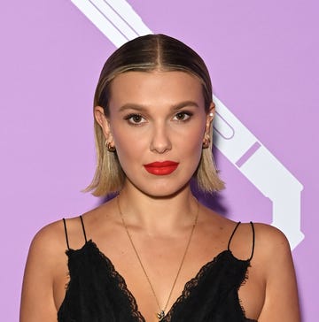 millie bobby brown with blonde bob and red lip poses for carpet