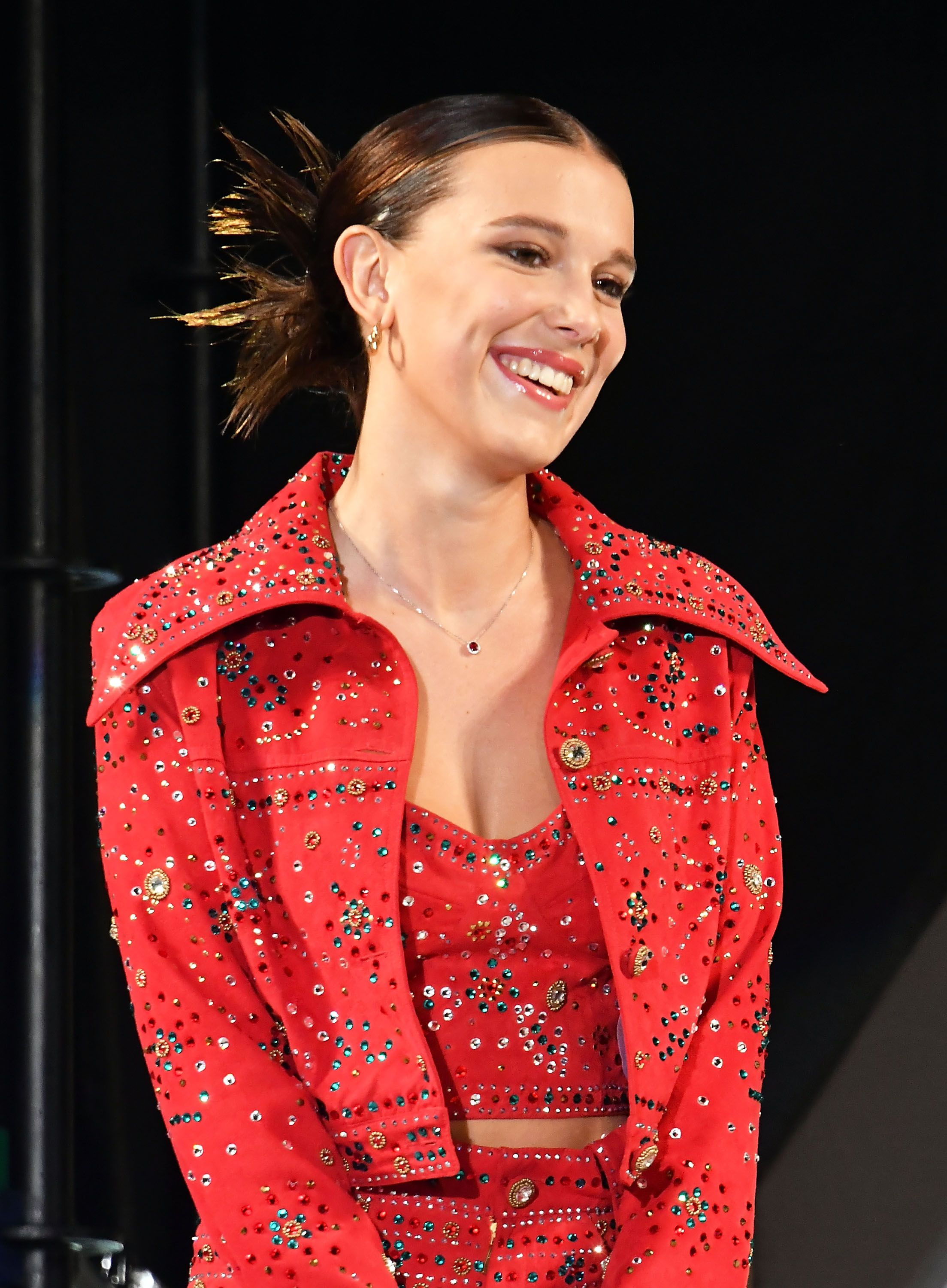 Millie Bobby Brown wears a red bejewelled co-ord and cowboy boots