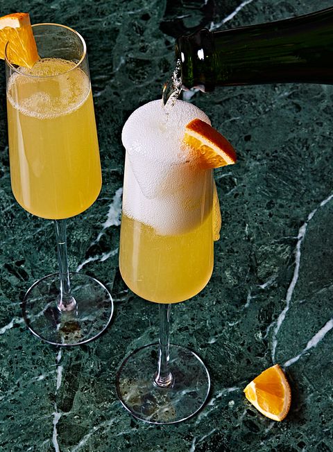 mimosa in a glass garnished with an orange wedge
