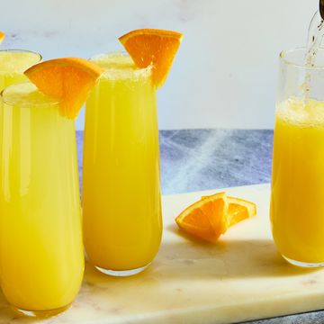orange juice and champagne in a flute garnished with an orange wedge