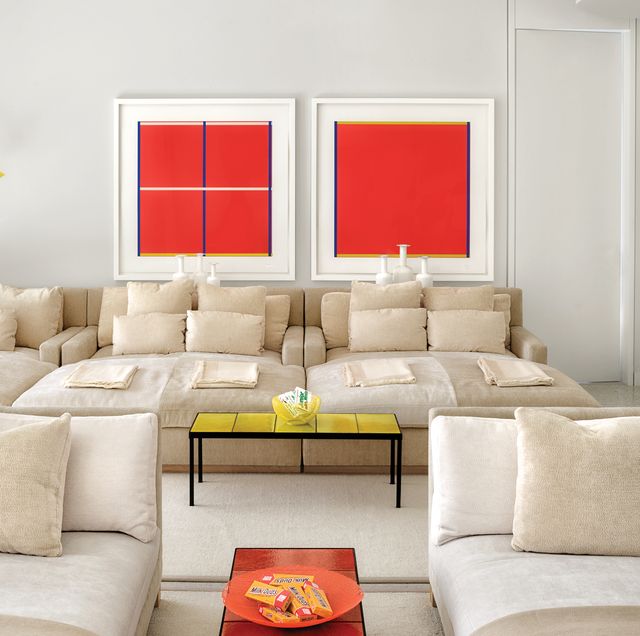 Screening room with light-colored chaises and red artwork