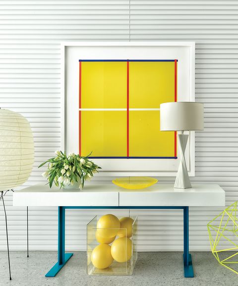 White entryway table with blue legs and white and yellow accents and artwork