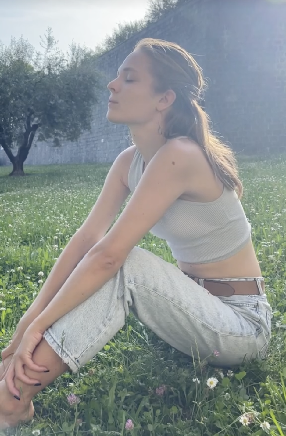 a woman sitting in a grassy area
