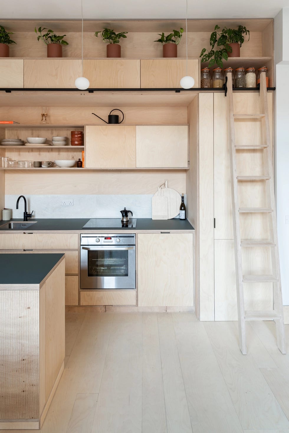 cocina de madera contrachapada con escalera para acceder al sistema de almacenaje