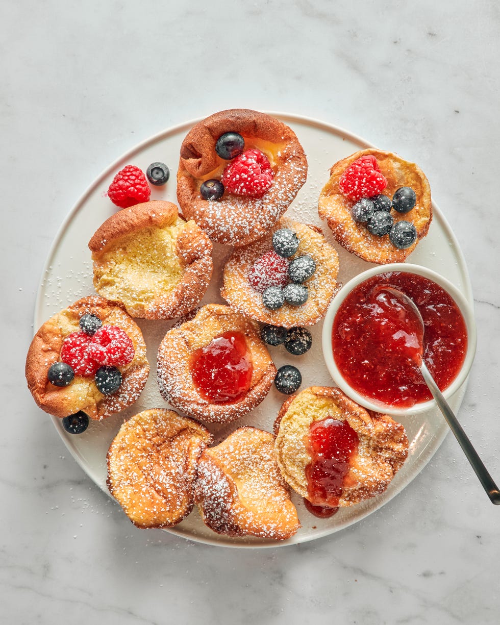 mini dutch baby pancakes with berries jam and confectioners sugar