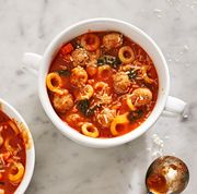 mini meatballs and anelletti ring shaped pasta sit inside two bowls of marinara soup