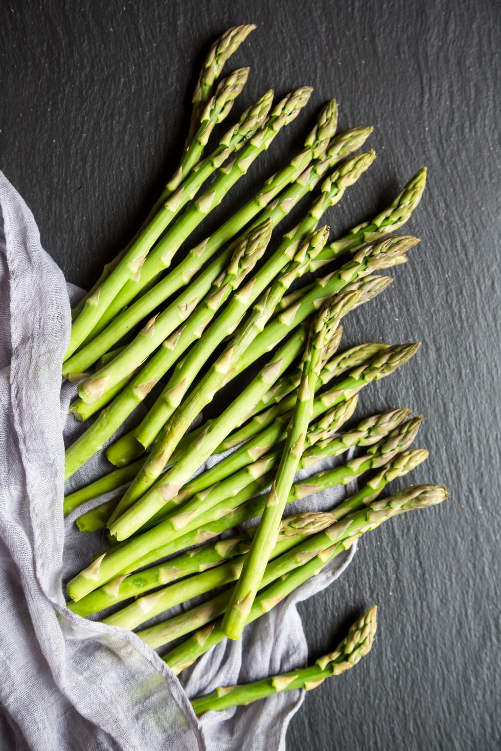 mini organic green asparagus on slate