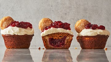 mini pumpkin cupcakes filled with small pies topped with whipped cream and cranberry sauce