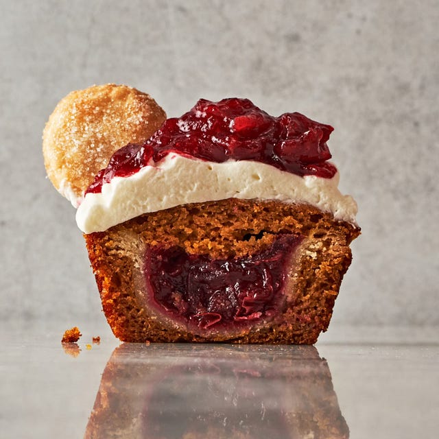 mini pumpkin cupcakes filled with small pies topped with whipped cream and cranberry sauce