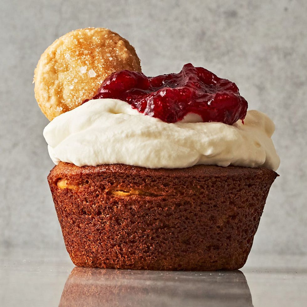 mini pumpkin cupcakes filled with small pies topped with whipped cream and cranberry sauce