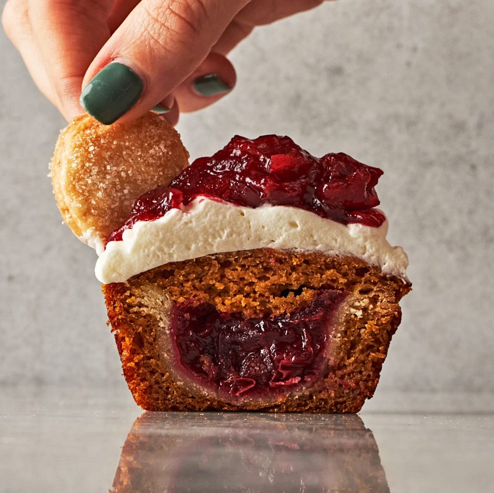 mini pumpkin cupcakes filled with small pies topped with whipped cream and cranberry sauce