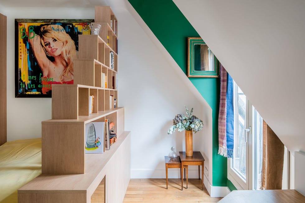 Espacio entre la cama y el ventanal decorado con dos mesas auxiliares de madera