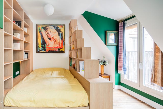Pequeño dormitorio con estanterías de madera a cada lado