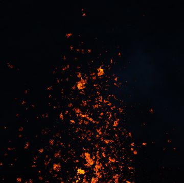 minimal shot showing lava erupting skywards photographed from close up at night, reykjanes peninsula, iceland