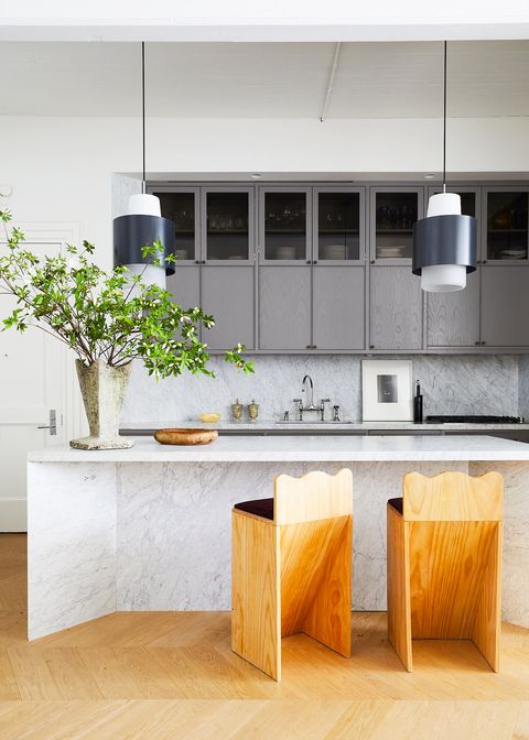 modern kitchen with marble island and wooden stools