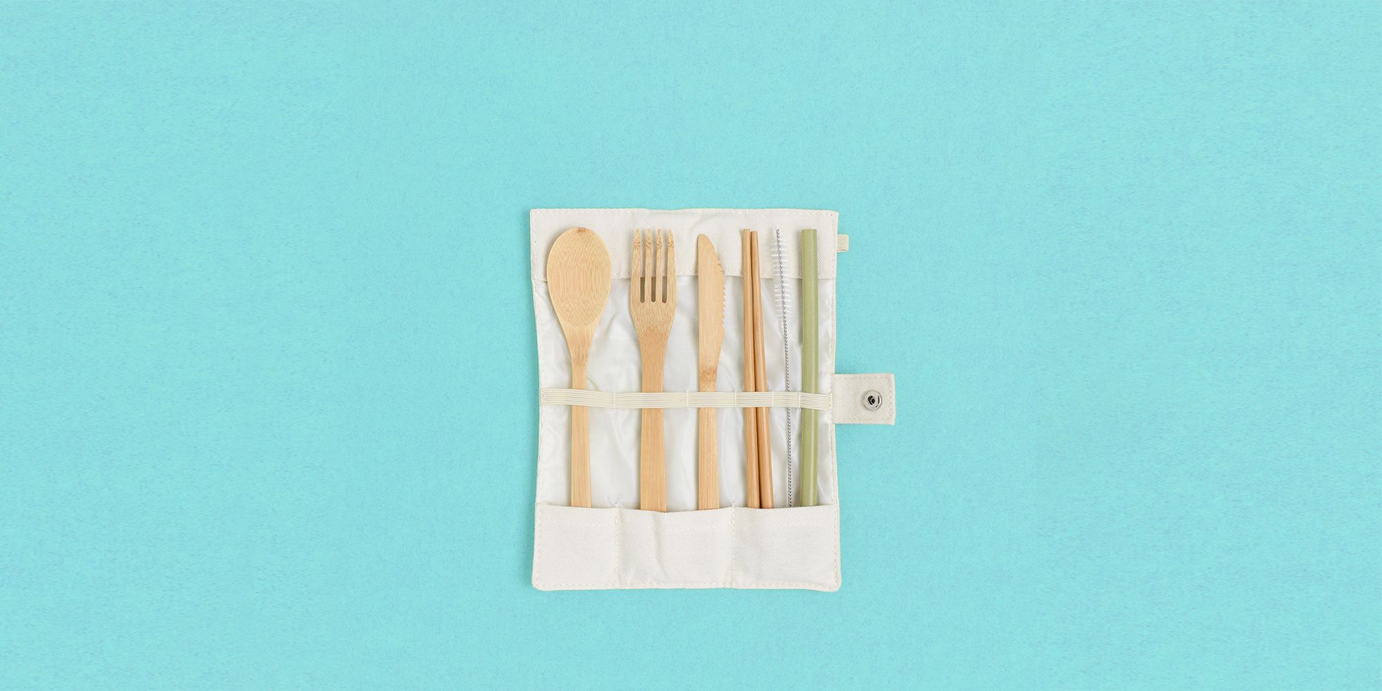 set of bamboo cutlery in a case on a green pastel background zero waste concept