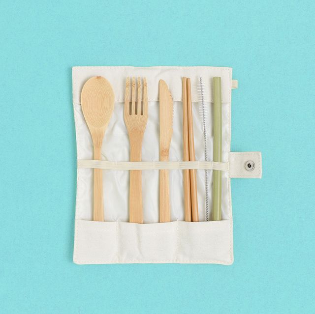 set of bamboo cutlery in a case on a green pastel background zero waste concept