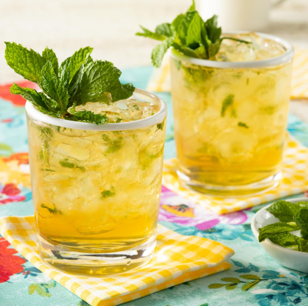 mint julep in two glasses with fresh mint and yellow napkins