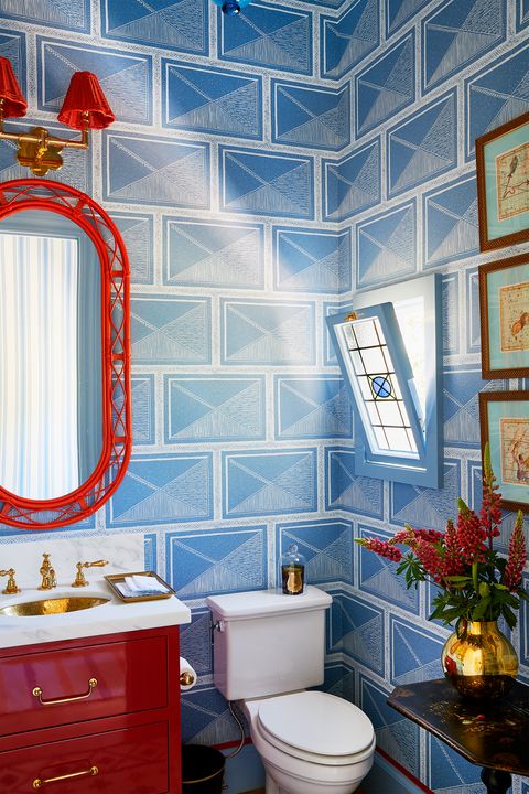 red mirror in wallpapered bathroom