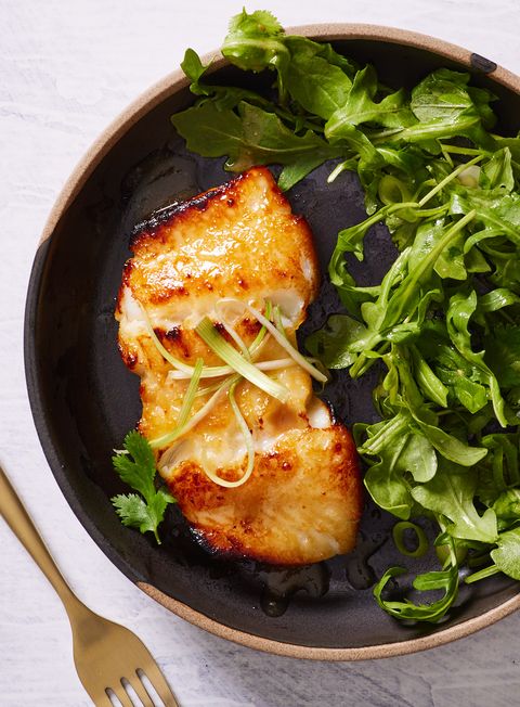 miso marinated chilean sea bass with wilted arugula on a plate