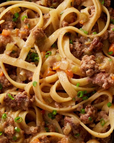 close up of miso fettuccine bolognese garnished with scallions
