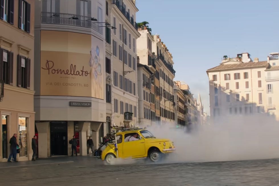 yellow fiat 500 drifts around rome