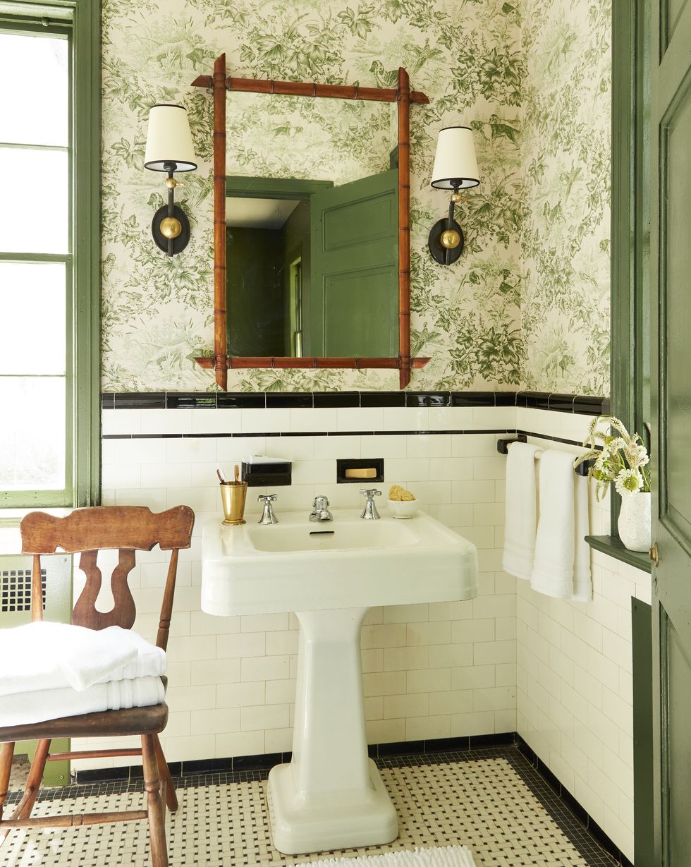 bathroom with green floral wallpaper and white tile wainscoting with black tile trim
