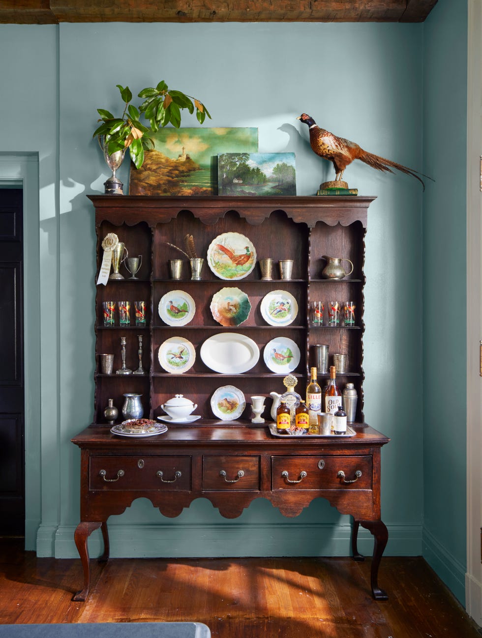 hutch with china and stuffed pheasant on top