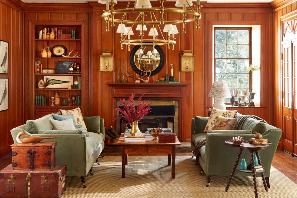 living room with wood paneled walls and two green sofas