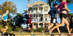 runners in the mississippi gulf coast marathon pass in front of a house